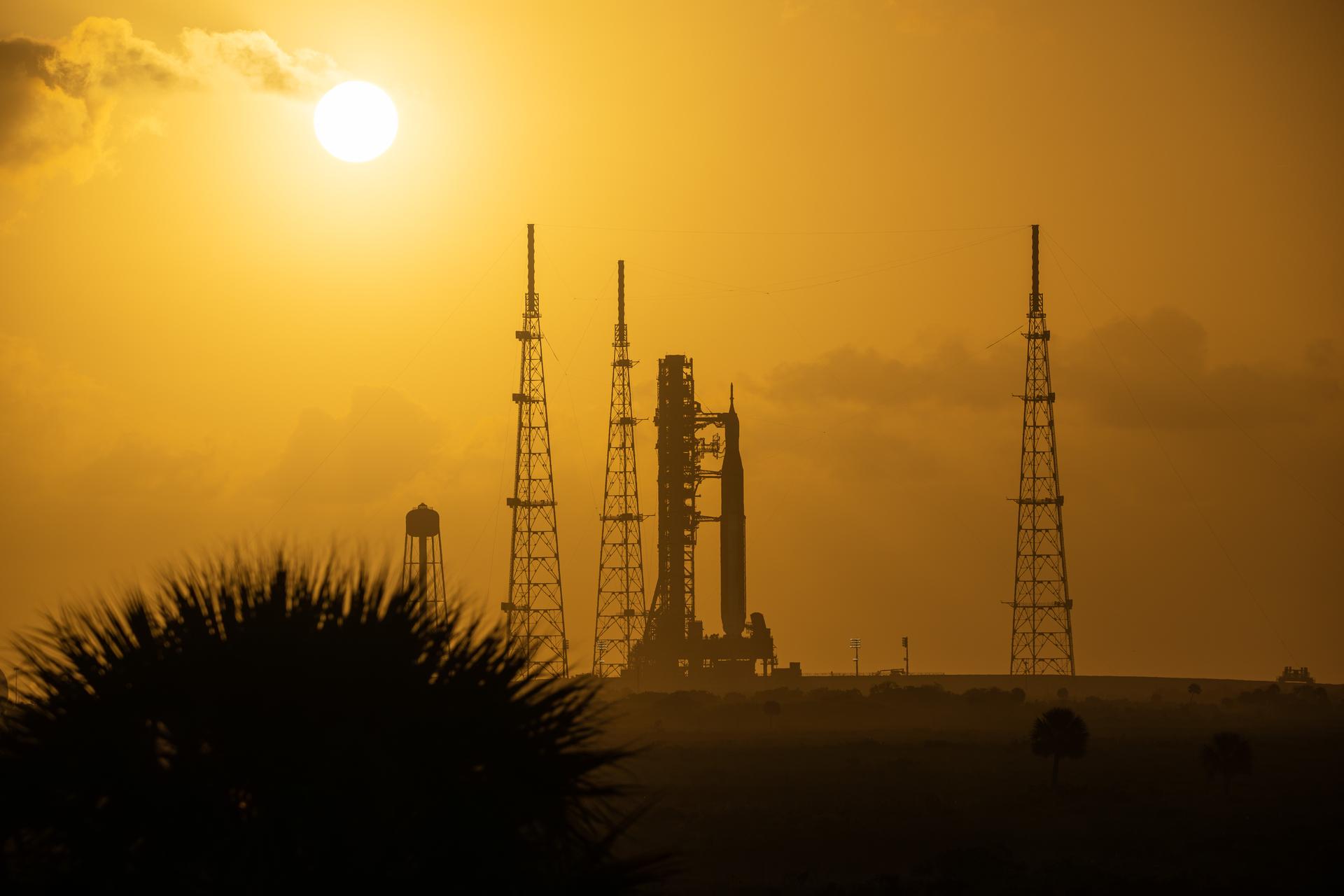This image shows a sunset of NASA’s SLS (Space Launch System) and Orion spacecraft at NASA’s Kennedy Space Center. NASA's massive Crawler-Transporter, upgraded for the Artemis program, carried the powerful SLS rocket and Orion spacecraft on the Mobile Launcher from the Vehicle Assembly Building to Launch Pad 39B at Kennedy Space Center in preparation for the Artemis II mission.